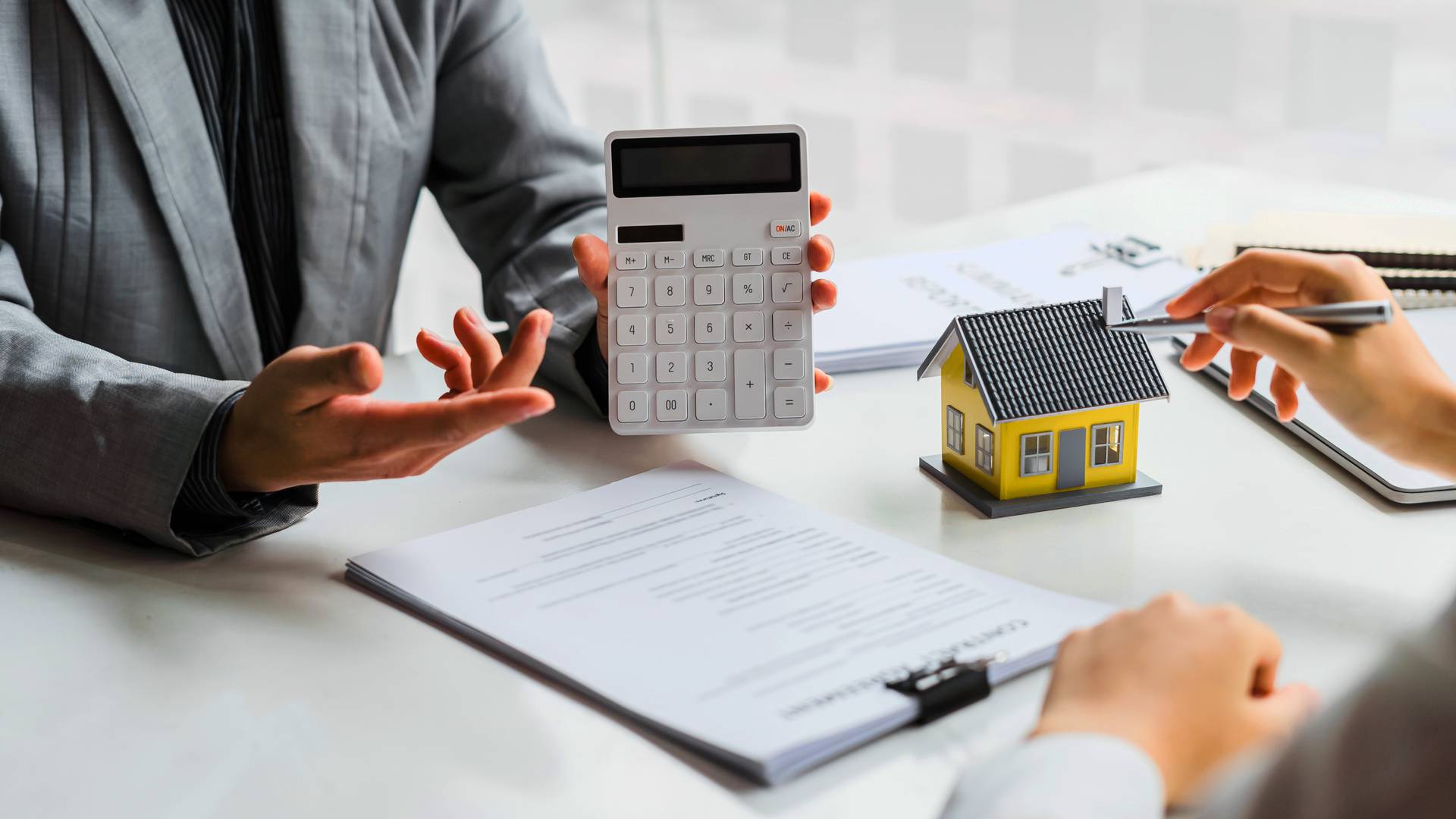 agent nieruchomości pokazuje na kalkulatorze ratę kredytu hipotecznego -  w 2021