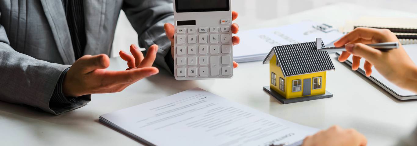 agent nieruchomości pokazuje na kalkulatorze ratę kredytu hipotecznego