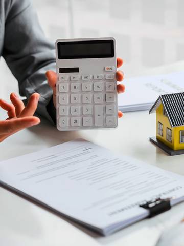 agent nieruchomości pokazuje na kalkulatorze ratę kredytu hipotecznego