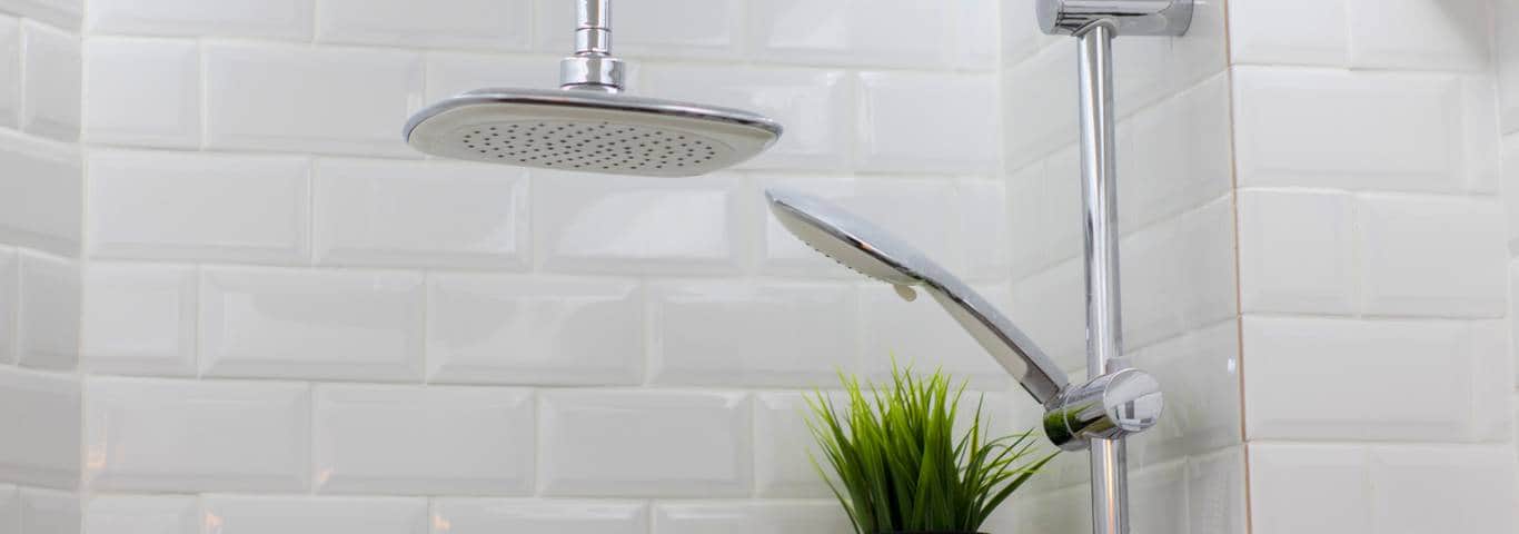 białe płytki na ścianie pod prysznicem