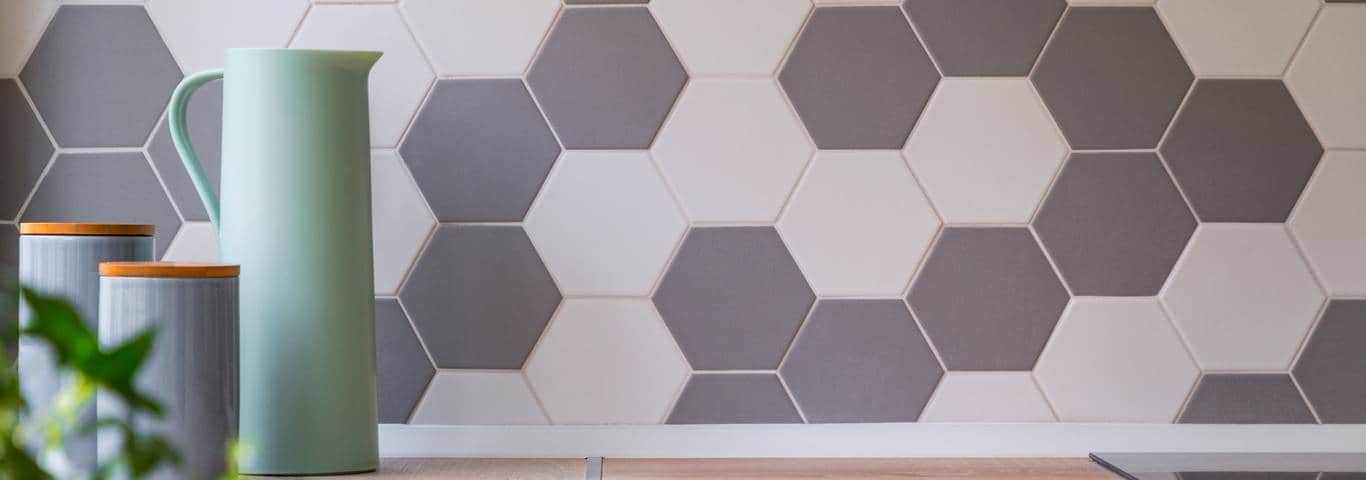 szaro-białe płytki heksagonalne ułożone nad blatem kuchennym drewnopodobnym