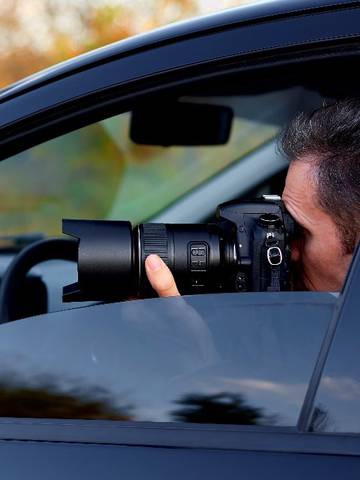 detektyw robi zdjęcie z ukrycia z samochodu