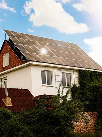 Dom jednorodzinny z panelami fotowoltaicznymi zainstalowanymi na połaci dachu