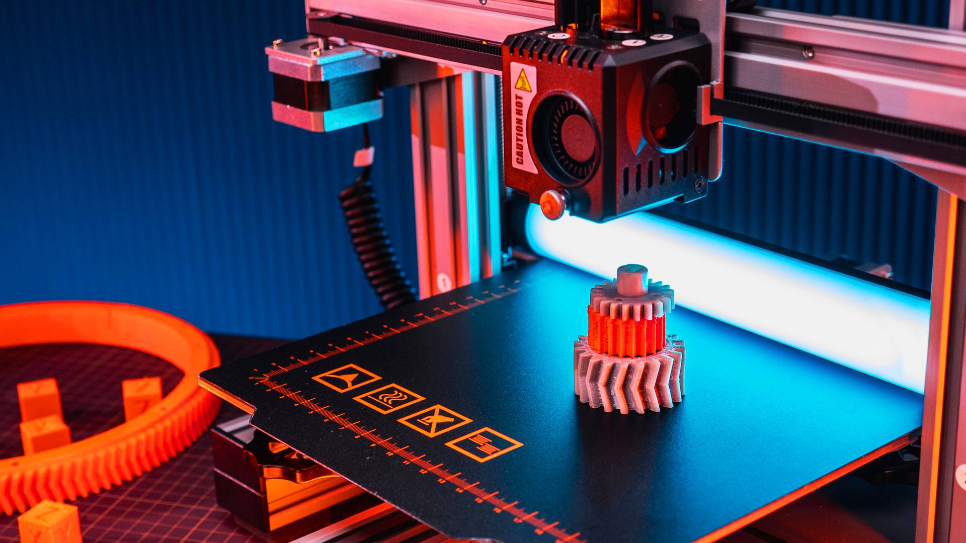 Drukarka 3D drukująca zębaty element z tworzywa na stole roboczym