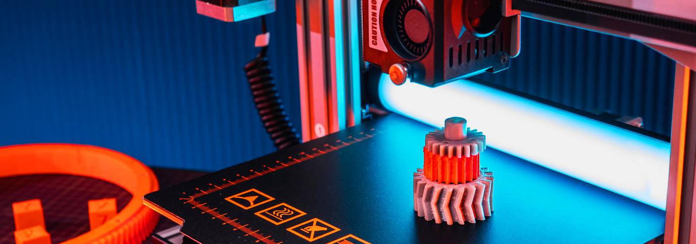 Drukarka 3D drukująca zębaty element z tworzywa na stole roboczym