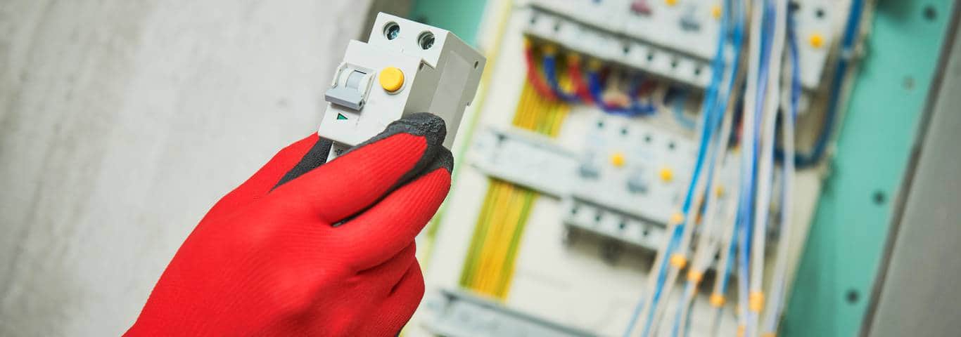 Elektryk montuje wyłącznik różnicowoprądowy w rozdzielnicy elektrycznej