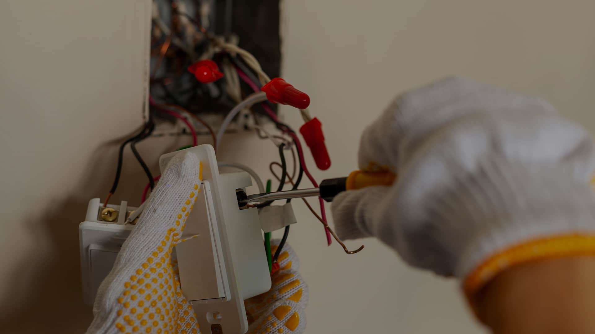 Elektryk montujący włącznik światła w puszce instalacyjnej