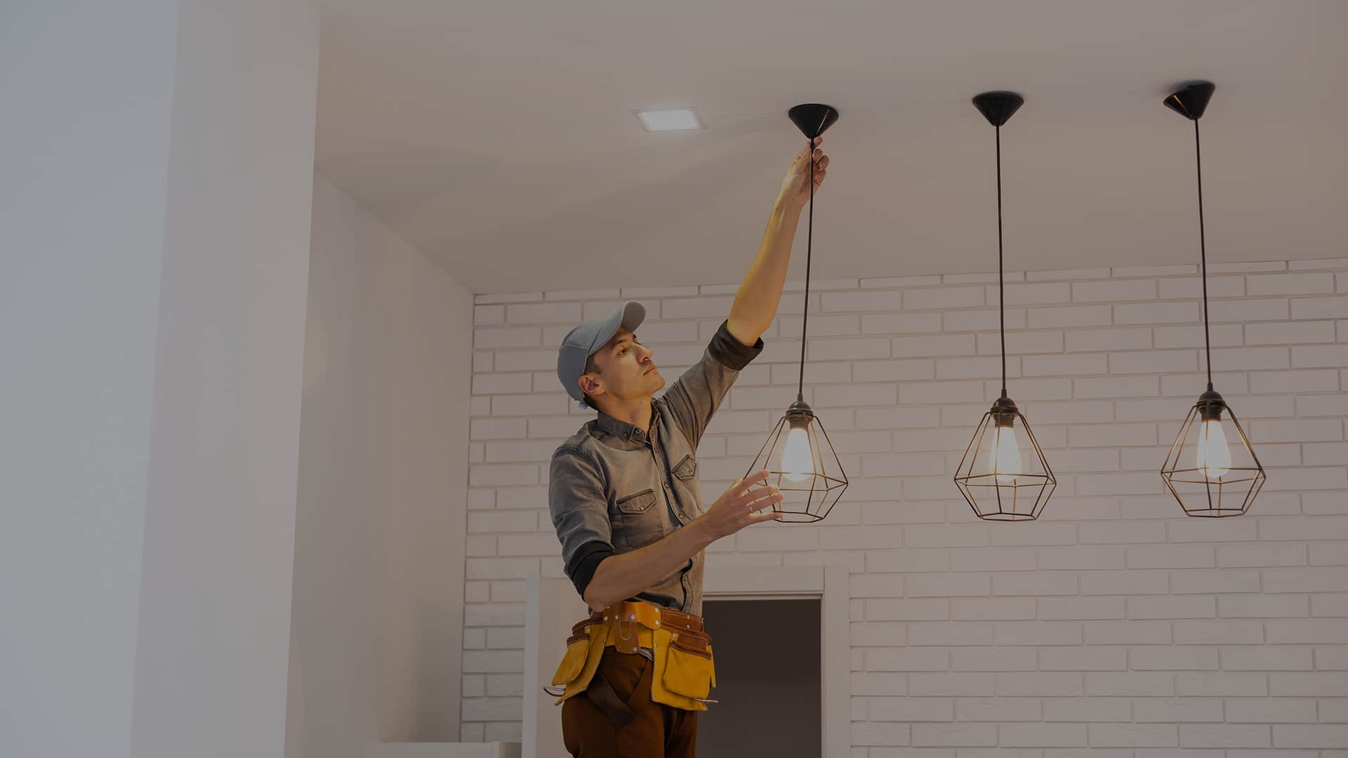 Elektryk montuje lampy sufitowe w stylu loftowym