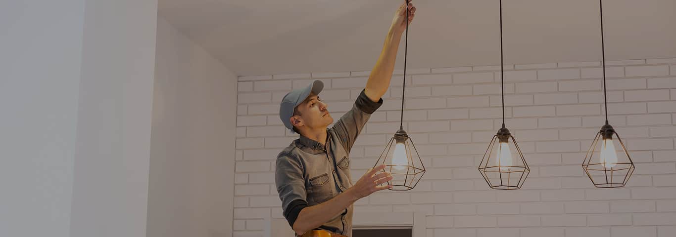 Elektryk montuje lampy sufitowe w stylu loftowym