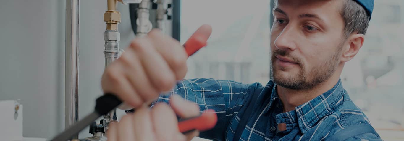 Hydraulik podłącza pralkę do instalacji wodnej w łazience