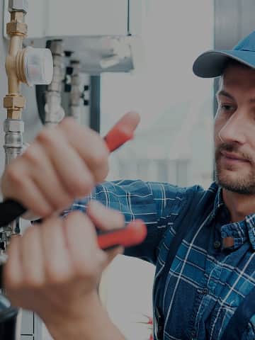 Hydraulik podłącza pralkę do instalacji wodnej w łazience