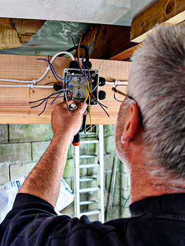 elektryk rozprowadza instalację elektryczną w garażu