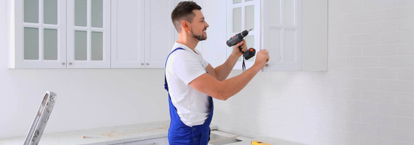 stolarz montuje meble kuchenne na wymiar