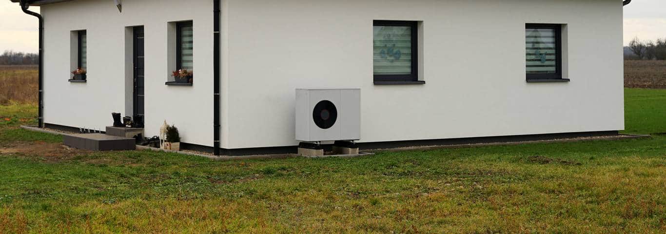 zewnętrzna jednostka pompy ciepła na tle elewacji nowoczesnego domu