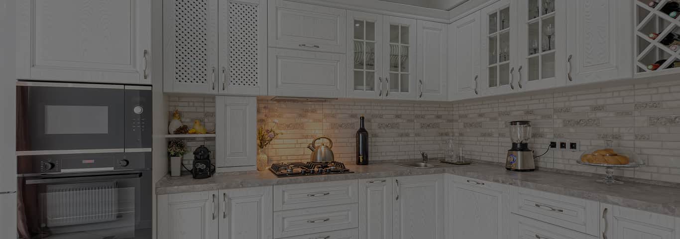 klasyczna biała kuchnia w zabudowie z frontami frezowanymi i szafkami ze szkłem