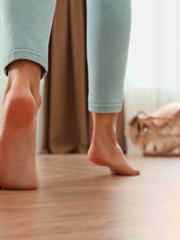 kobieta chodzi boso po parkiecie