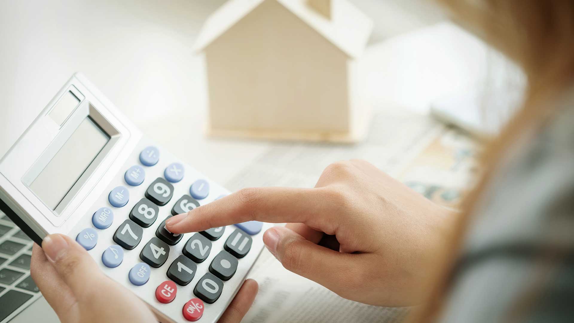 kobieta oblicza na kalkulatorze ratę kredytu hipotecznego
