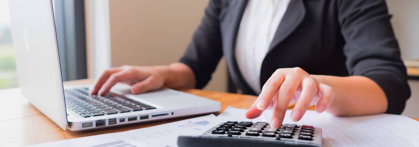 kobieta wylicza na kalkulatorze opłacalność zmiany oprocentowania kredytu hipotecznego na stałe