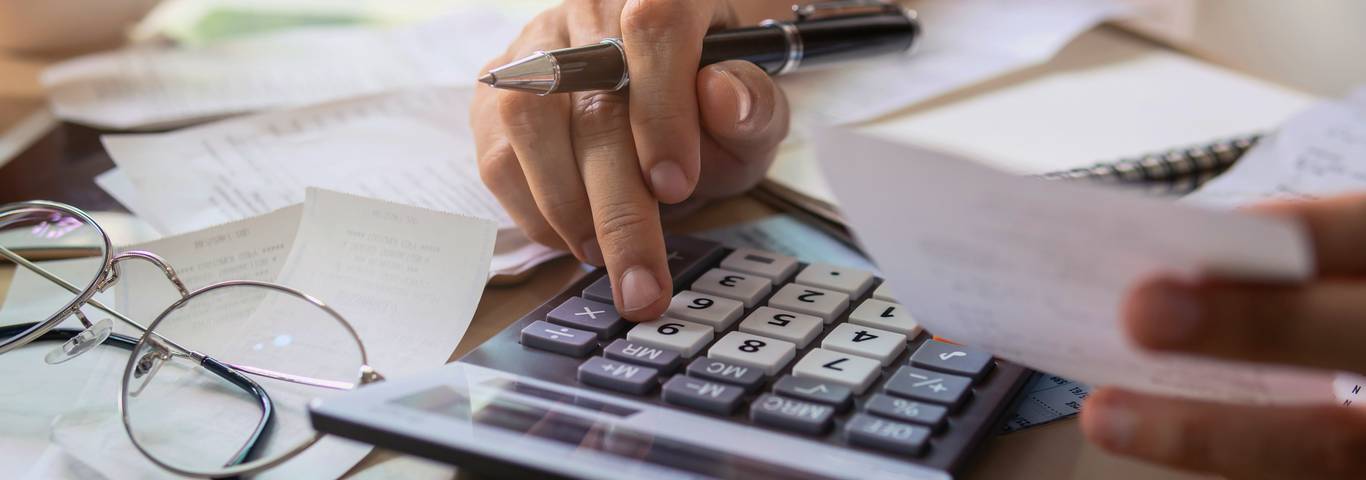 kobieta prowadząca księgowość robi wyliczenia podatków na kalkulatorze