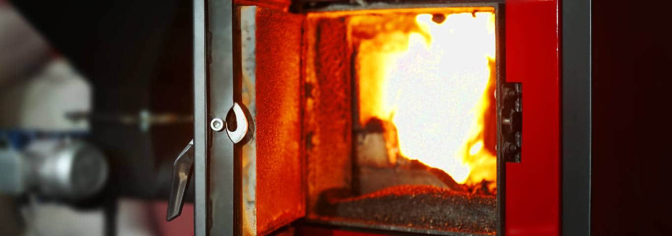 zbliżenie na otwarte drzwiczki kotła na paliwo stałe