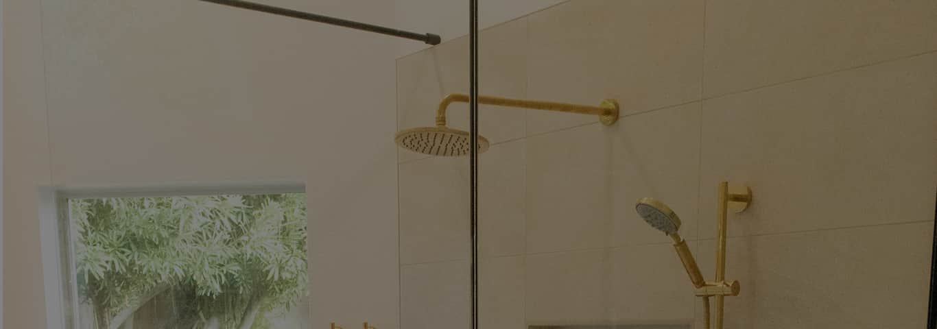 Elegancka łazienka z prysznicem i złotą armaturą z odpływem liniowym