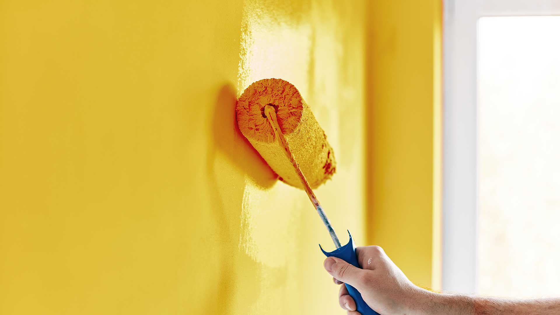 specjalista maluje ścianę na kolor żółty -  w 2021