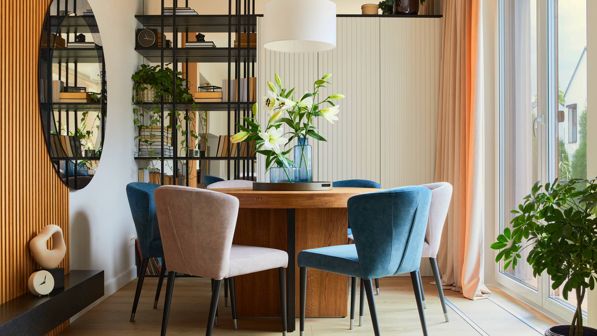 wnętrze małego salonu ze stołem jadalnianym i designerskimi krzesłami