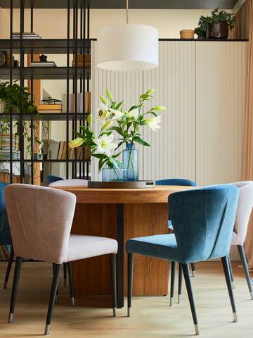 wnętrze małego salonu ze stołem jadalnianym i designerskimi krzesłami