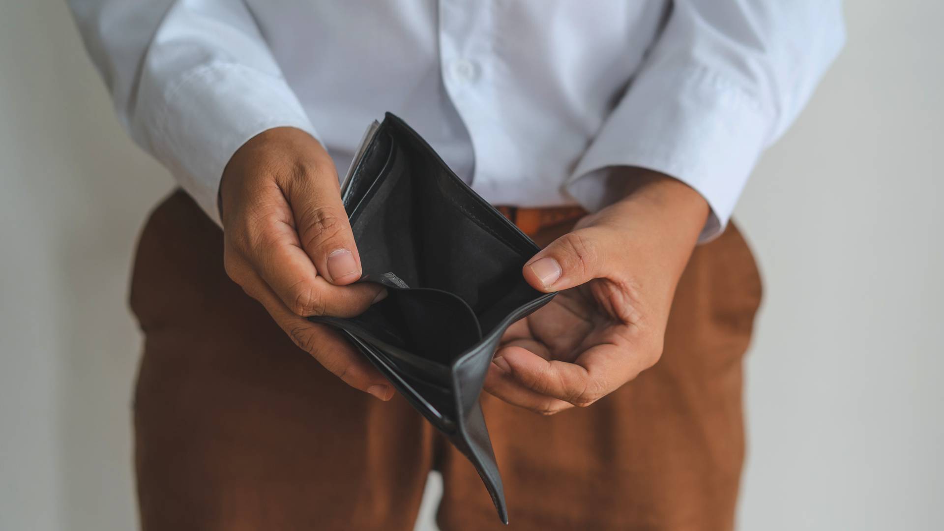 biznesmen pokazuje pusty portfel symbolizujący upadłość konsumencką