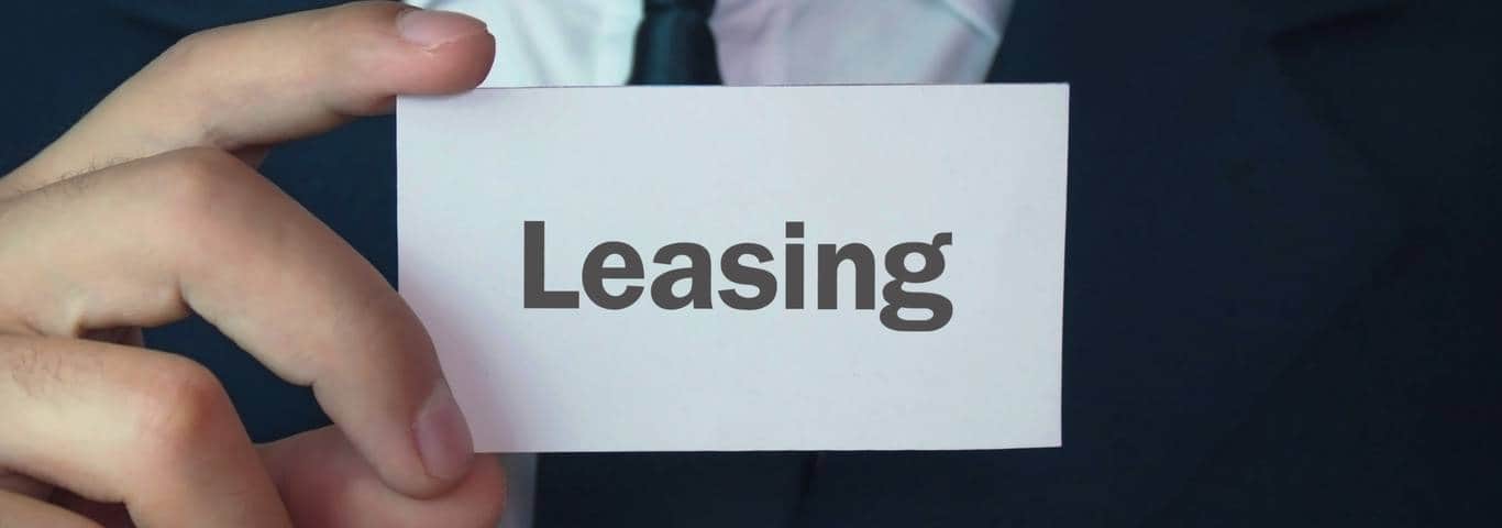 zbliżenie na wizytówkę z napisem leasing trzymaną przez mężczyznę w garniturze