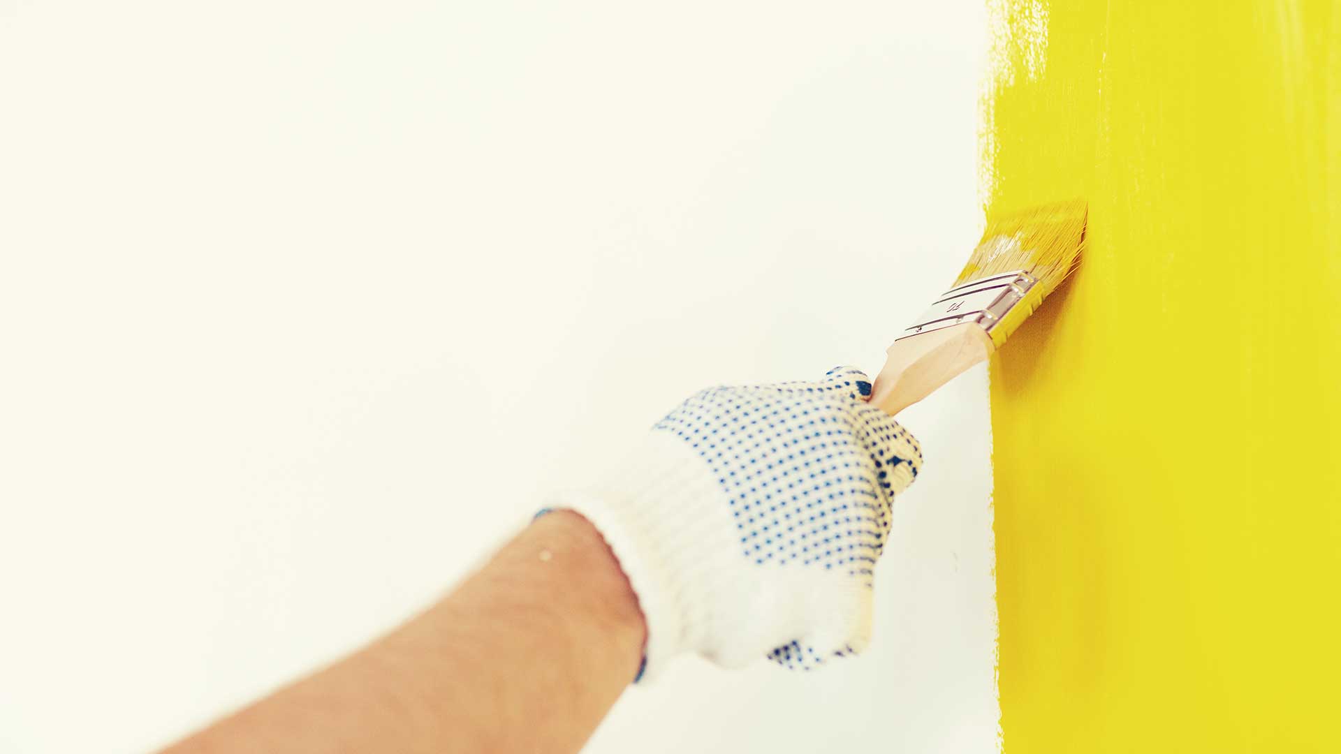 specjalista maluje ściany małym pędzlem na żółto -  w 2021