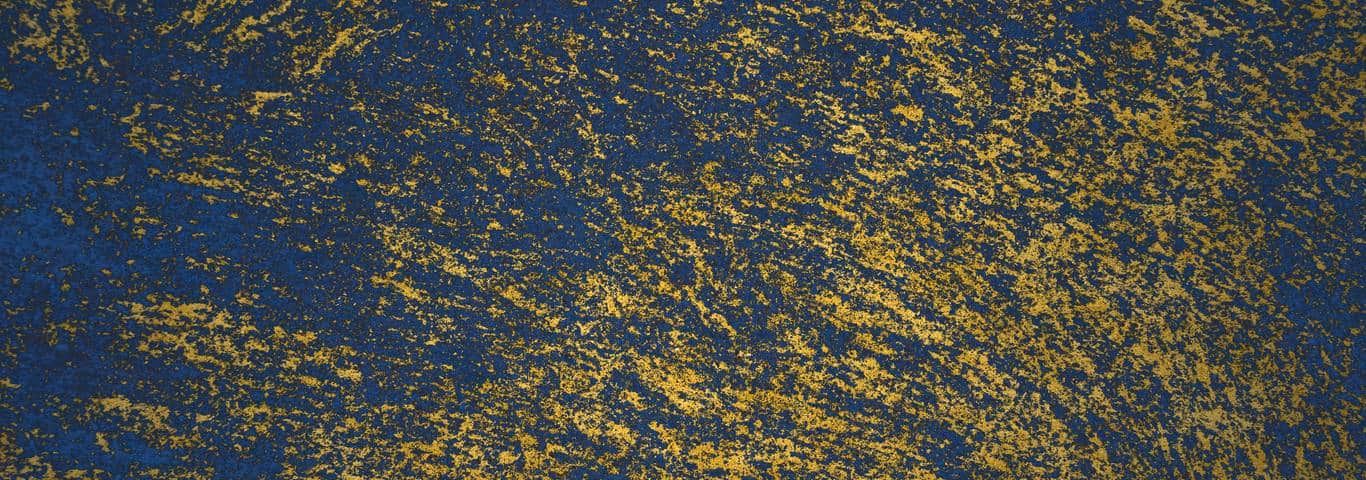 drobinki złotego brokatu na niebieskiej ścianie