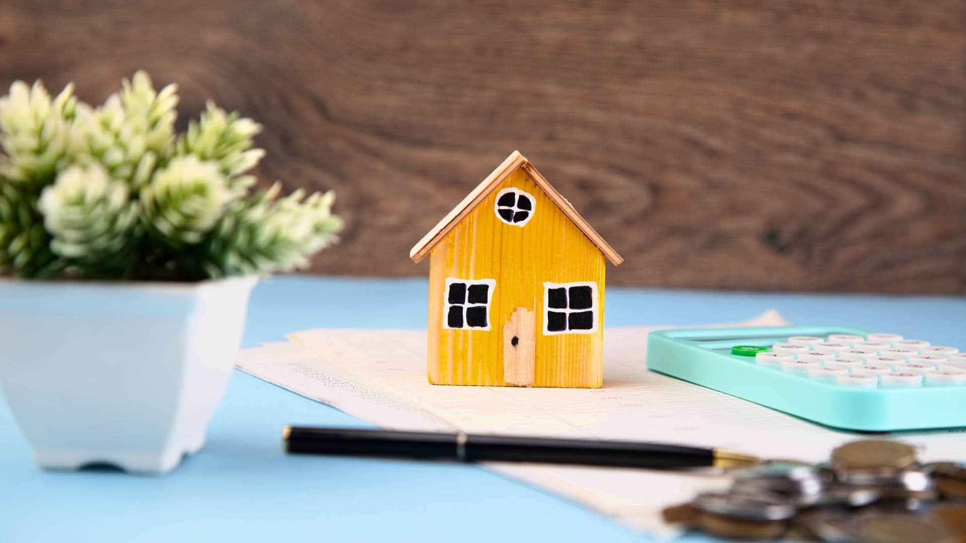 Model domu z monetami i dokumentami jako symbol inwestycji w fotowoltaikę z magazynem energii