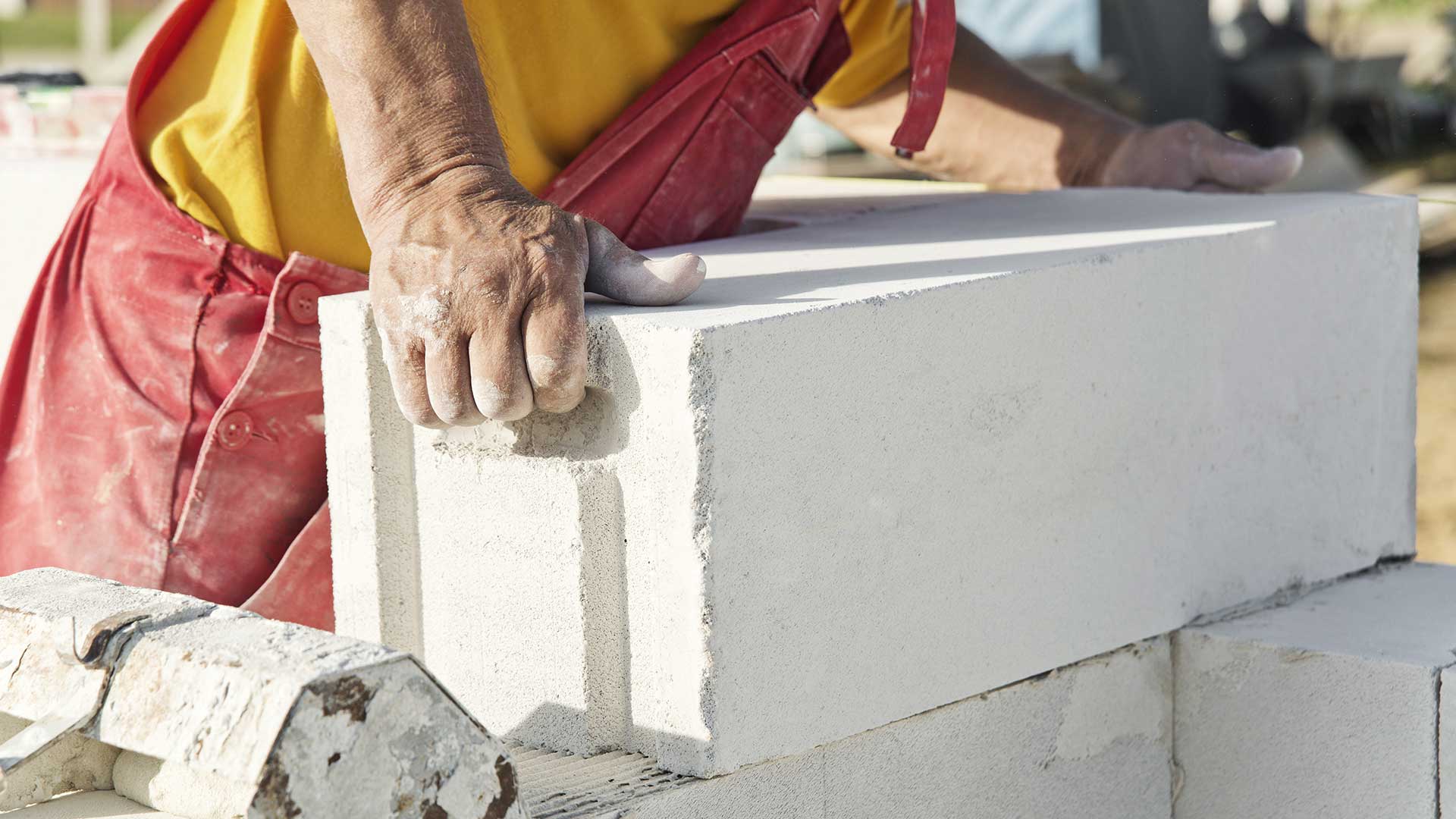 budowniczy muruje ścianę domu z betonu komórkowego -  w 2022