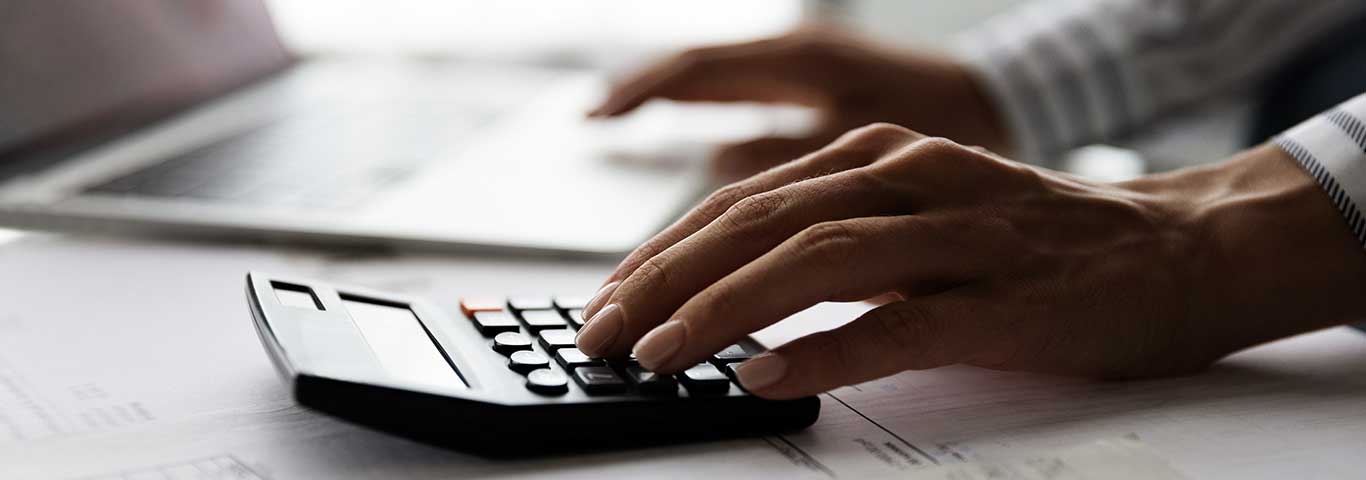 kobieta oblicza wysokość kredytu hipotecznego na czarnym kalkulatorze