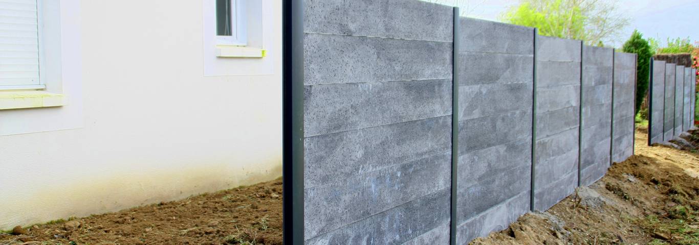 ogrodzenie betonowe z płyt betonowych prełnych na tle domu