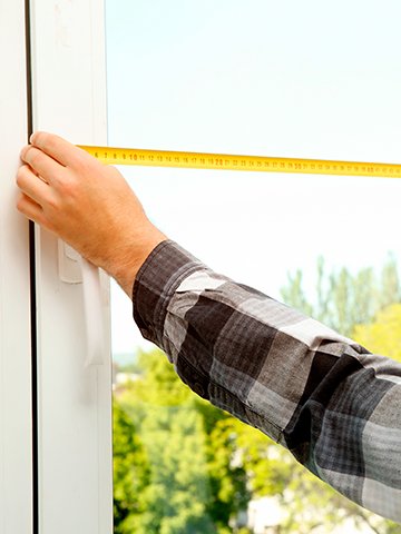specjalista mierzy szerokość okna w domu