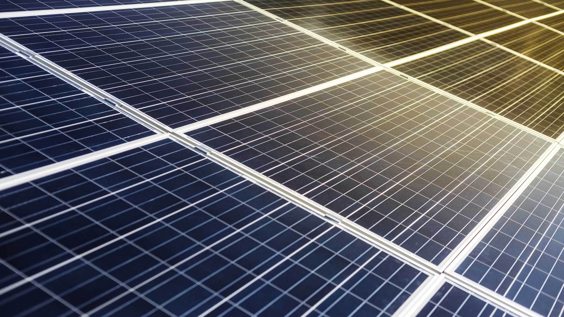 Zbliżenie na ogniwa panelu fotowoltaicznego oświetlone promieniami słońca