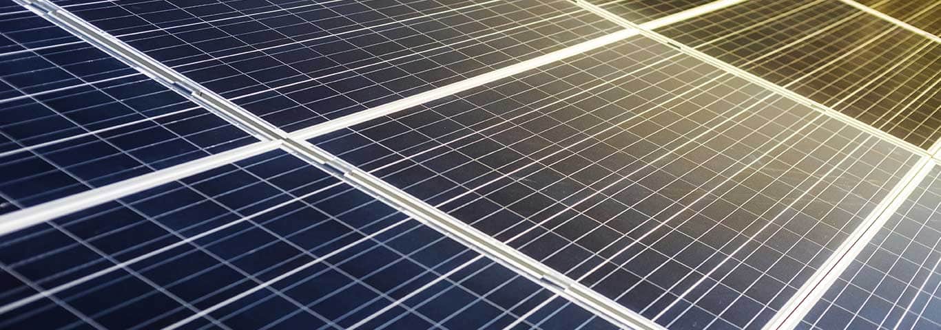 Zbliżenie na ogniwa panelu fotowoltaicznego oświetlone promieniami słońca