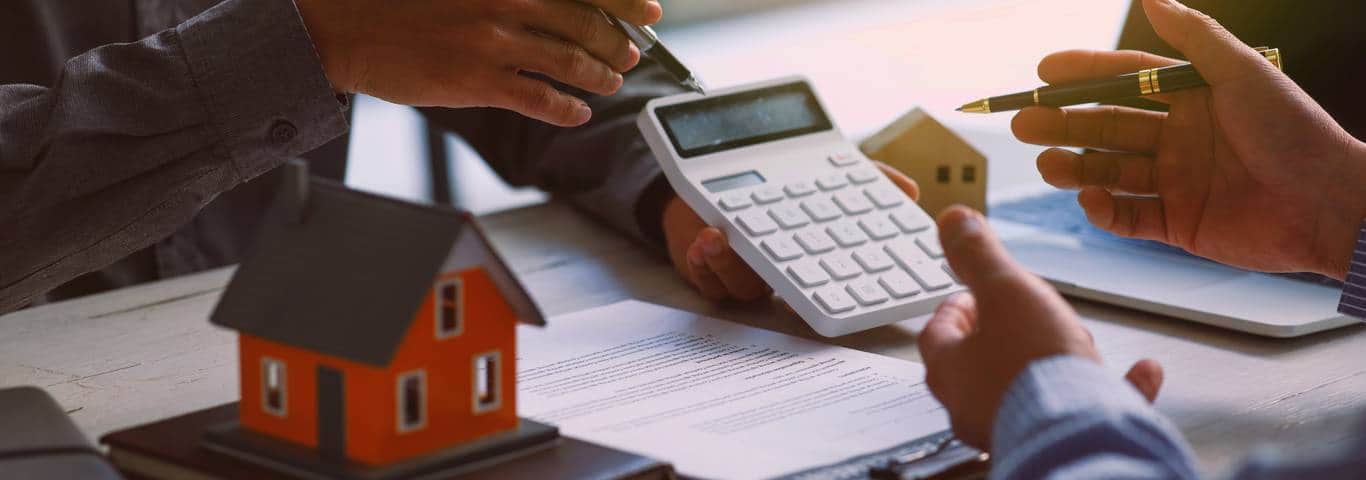 agent nieruchomości pokazuje na kalkulatorze cenę sprzedaży nieruchomości