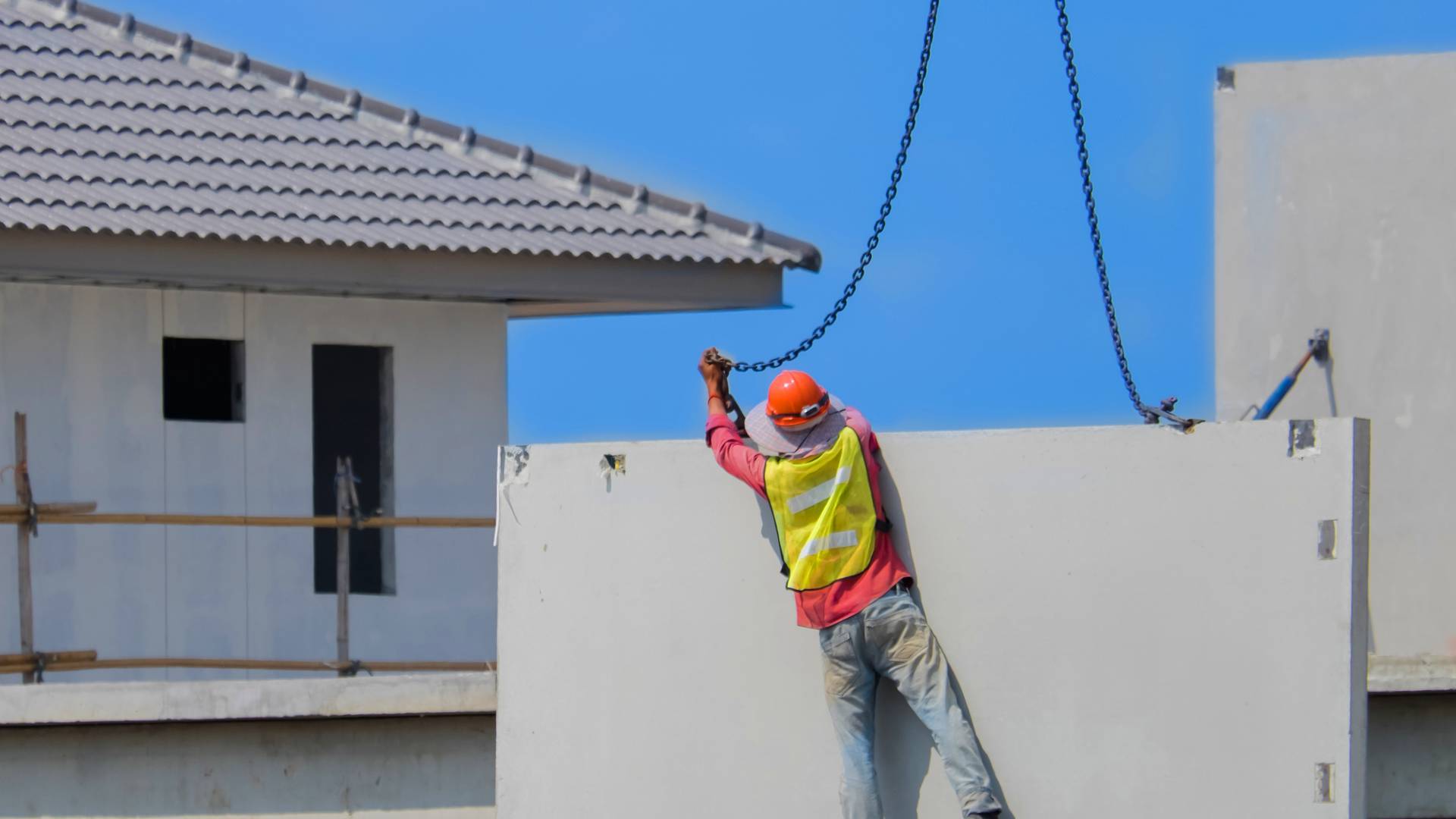 pracownik instaluje ścianę domu z prefabrykatów -  w 2023
