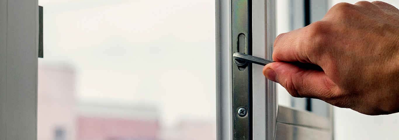 specjalista wykonuje regulację okna plastikowego z wykorzystaniem klucza