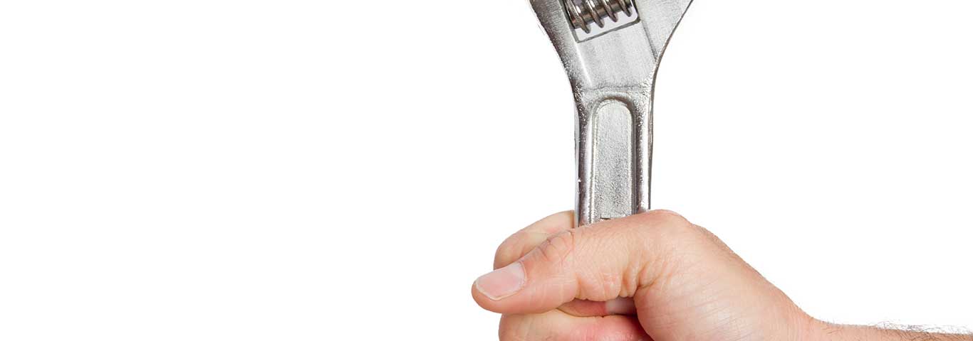 Zaciśnięta dłoń trzymająca klucz francuski – symbol wyboru solidnej firmy instalacyjnej