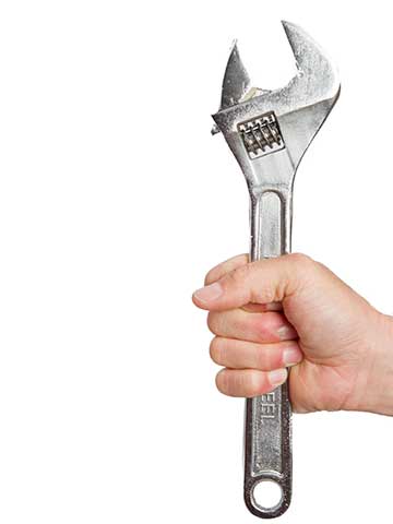 Zaciśnięta dłoń trzymająca klucz francuski – symbol wyboru solidnej firmy instalacyjnej