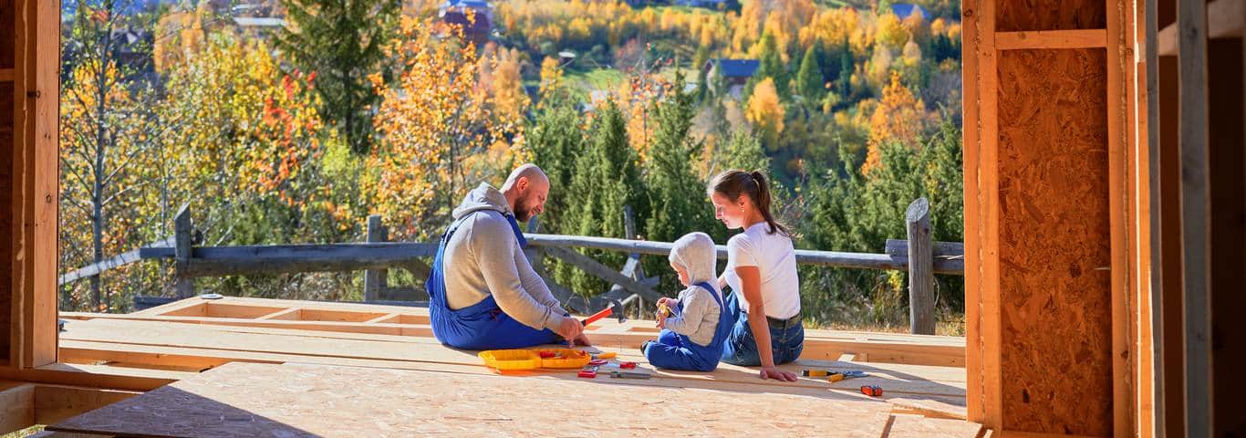 rodzina na tarasie domu w budowie w pięknej okolicy