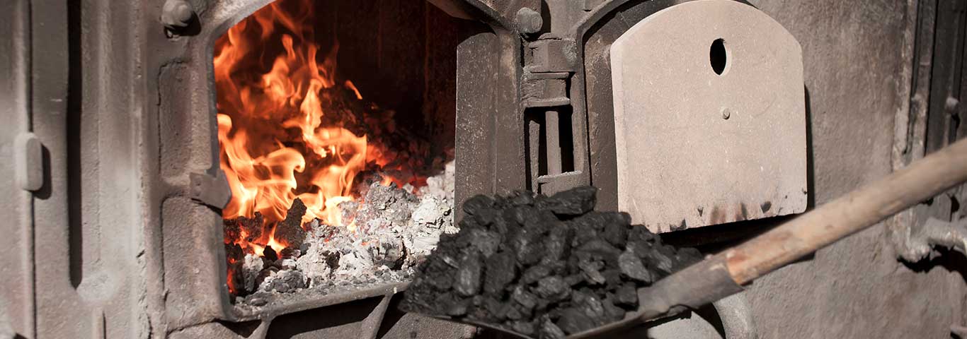 dokładanie węgla do starego pieca na węgiel