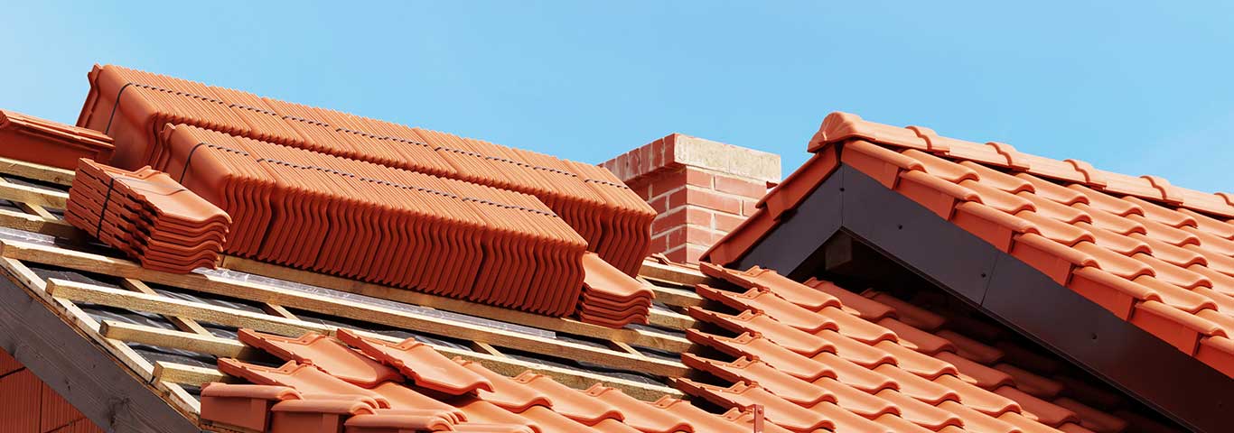 dach w budowie ze stosami czerwonej dachówki ceramicznej gotowej do zamocowania