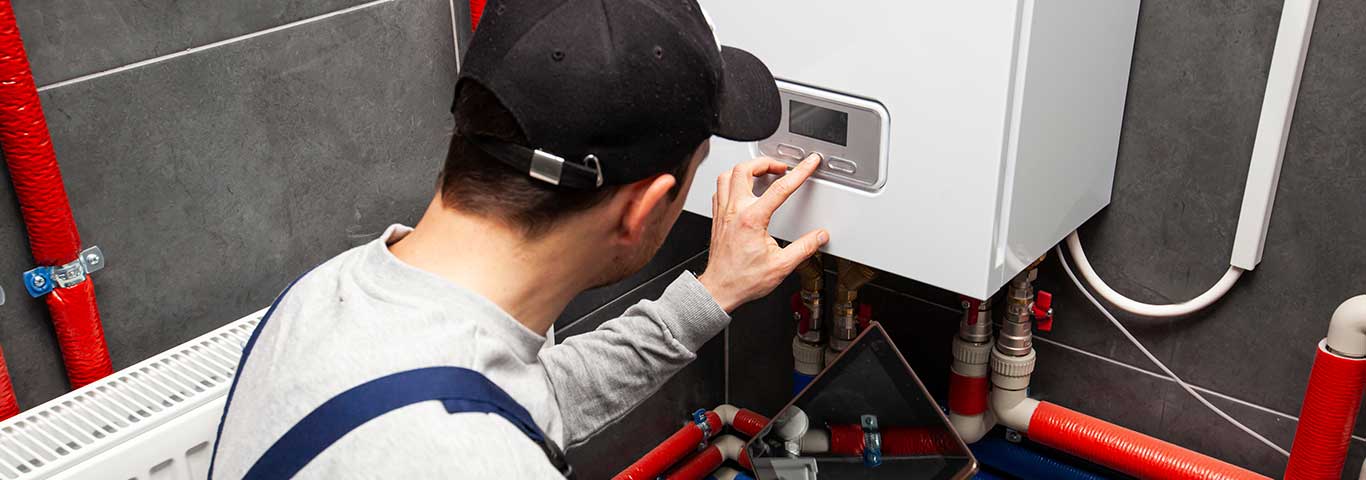 serwisant sprawdza instalację z pompą ciepła w kotłowni