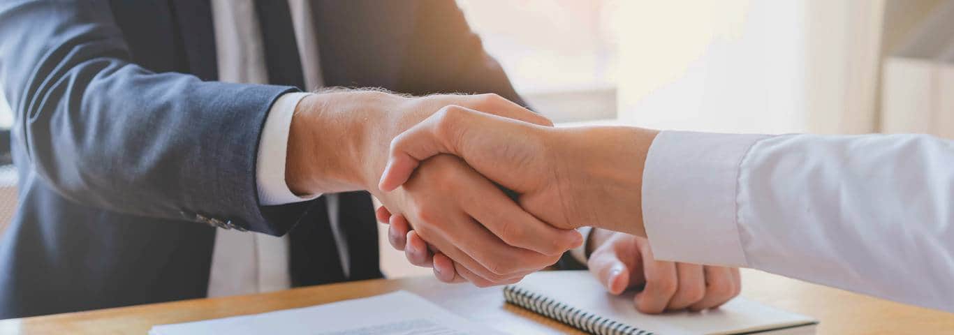 uścisk dłoni dwóch osób nad umową