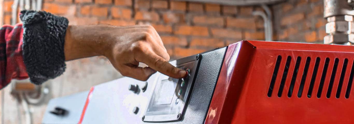 męska ręka ustawia parametry kotła na paliwo stałe